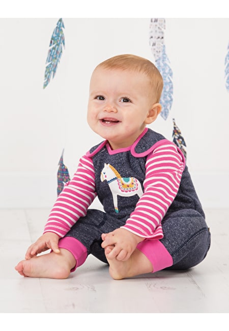 Baby mit Strampler Pferd von der Marke Frugi