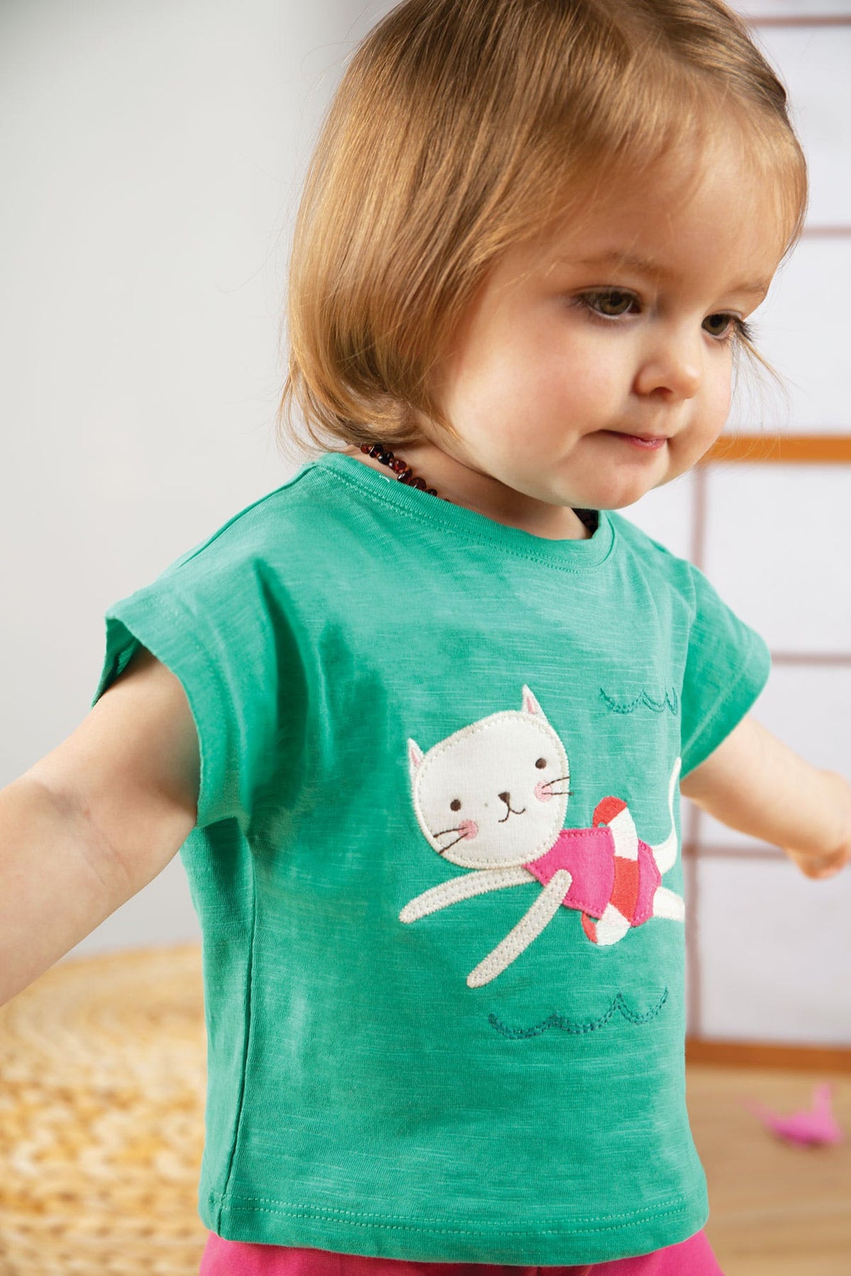Grünes T-Shirt mit Katze am schwimmen ( 0-3, 3-6 Monate)  von Frugi