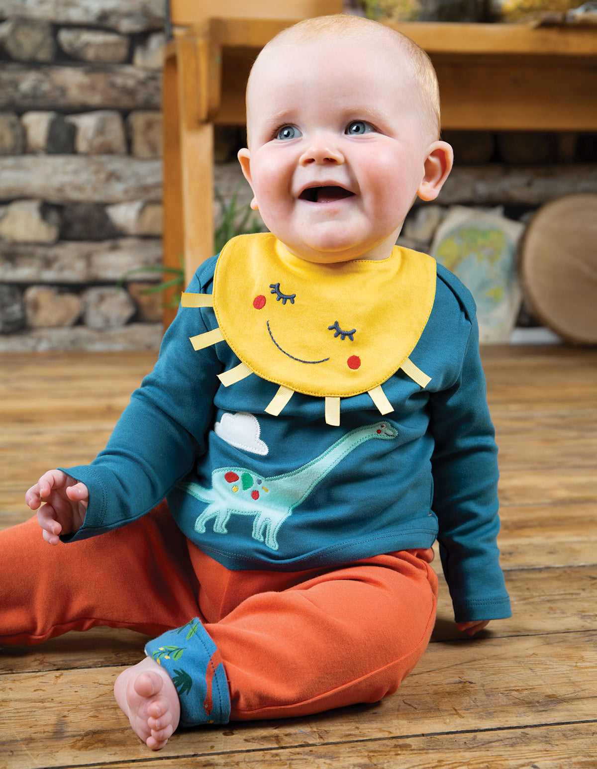 Baby mit Shirt mit Dinosaurier applikation von der Marke Frugi